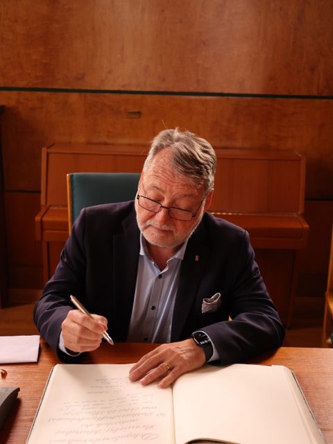 22. Mai 2026: Ein Moment der Stille: Lennarth Förberg, Gemeinderatsvorsitzender von Ronneby, trägt sich ins Goldene Buch des Bezirks ein