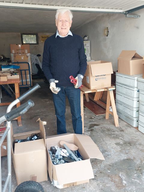 Orthopädietechniker Klaus Dittmer vor einer Paketsendung mit gespendeten Prothesenteilen
