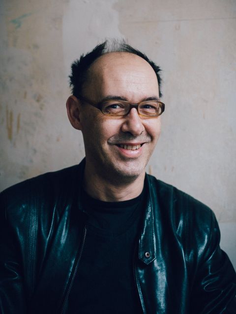 Eine Mann mit Brille lächelt in die Kamera.