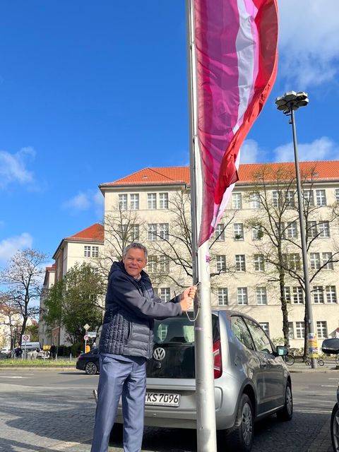 Bezirksbürgermeister Jörn Oltmann beim Hissen der Lesben*-Flagge