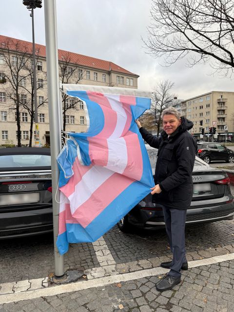 Bezirksbürgermeister Jörn Oltmann hisst die Trans_Flagge vor dem Rathaus Schöneberg.