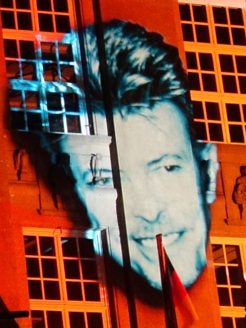 das Porträt eines Mannes, das an eine Häuserwand projiziert wird