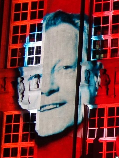 das Porträt eines Mannes, das an eine Häuserwand projiziert wird