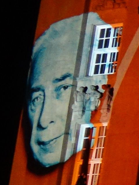 das Porträt eines Mannes, das an eine Häuserwand projiziert wird