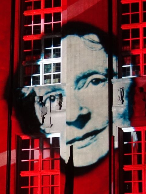 das Porträt einer Frau, das an eine Häuserwand projiziert wird