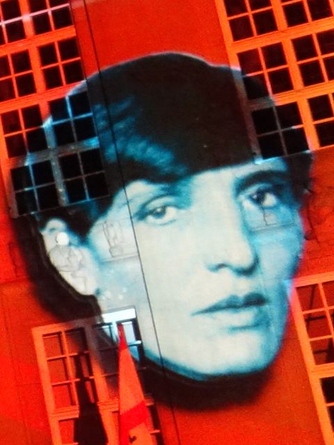 das Porträt einer Frau, das an eine Häuserwand projiziert wird