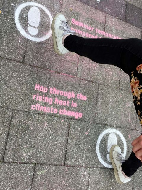 Füße treten auf auf den Bürgersteig gesprayte Fußtapsen.