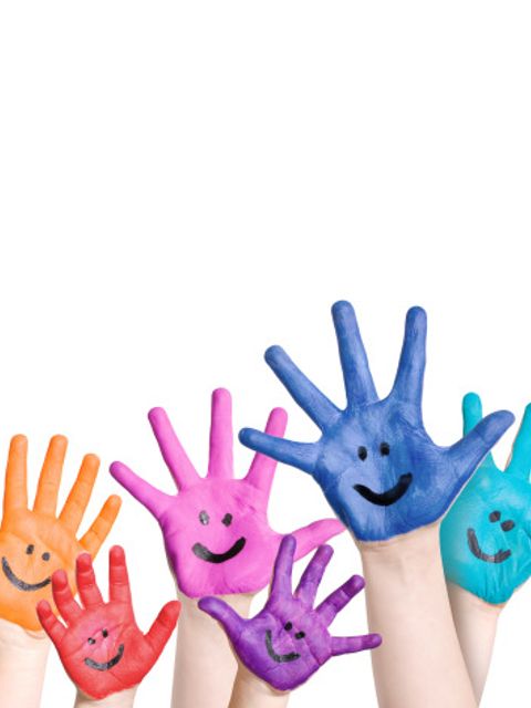 lachende Kinderhände in regenbogenfarben