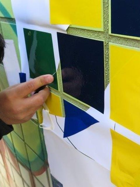 Ein Kind arbeitet an bunten Quadraten an der Wand