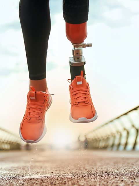 Never give up Cropped photo of disabled woman with prosthetic leg in sportswear jumping on the bridge