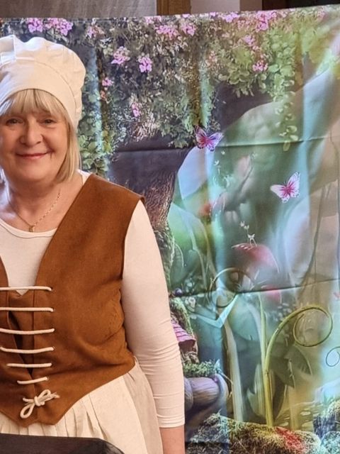 Frau in Kostüm lächelt in die Kamera
