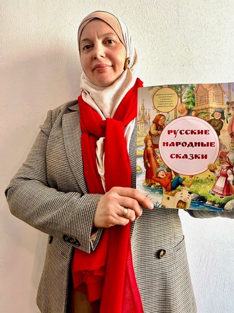 Fotografie einer Frau mit rotem Schal, die ein Bilderbuch zeigt