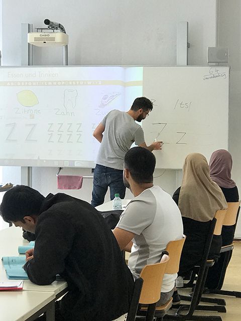 Kursleiter Reza Gamsavar erklärt das deutsche Alphabet