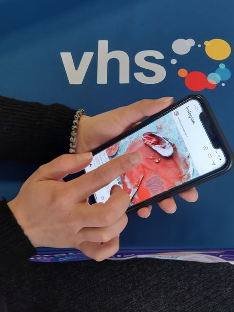 Eine Person scrollt auf einem Smartphone in der App Instagram