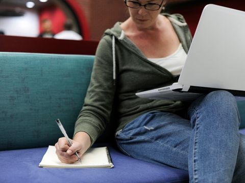 Frau, die in ein Notizbuch schreibt