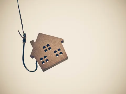 Ein Modellhaus aus Holz am Angelhaken