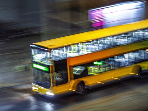 Schwenkaufnahme eines Stadtbusses in Berlin bei Nacht