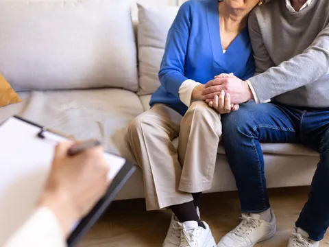 Seniorenpaar hält Händchen während einer Sitzung