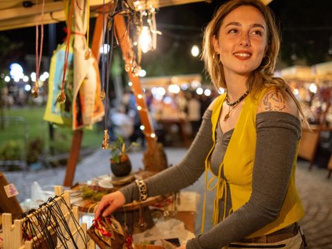 Eine junge Frau verkauft Halsketten auf einem Nachtmarkt.