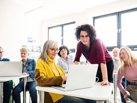 Gruppe von älteren Menschen nimmt mit Computer an Technikunterricht teil
