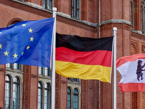 Drei wehende Flaggen vor dem Roten Rathaus, darunter die Europaflagge, die deutsche Flagge und die Berliner Landesflagge