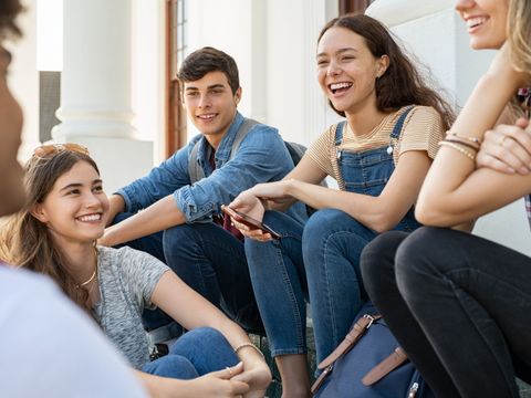 Junge Freundesgruppe sitzt zusammen und lacht