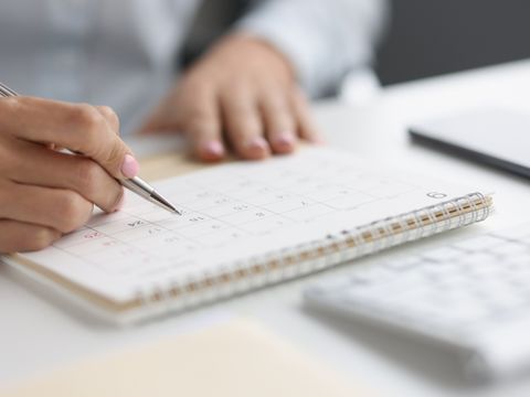 Eine Person schaut auf einem Tischkalender ein Datum nach