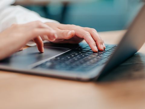 Hände tippen auf der Tastatur eines Laptops