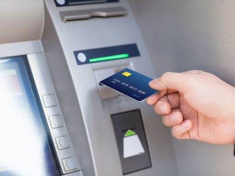 Hand schiebt Kreditkarte in Geldautomaten