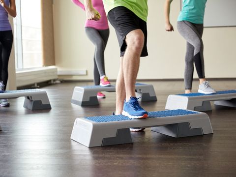 Gruppe von Menschen beim Step-Aerobic-Training in einem hellen Raum