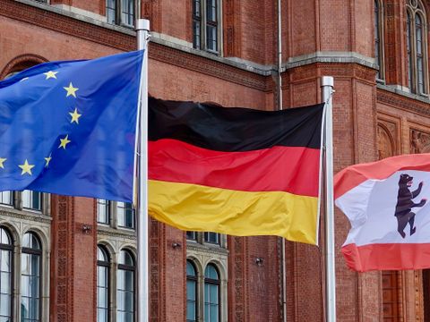Drei wehende Flaggen vor dem Roten Rathaus, darunter die Europaflagge, die deutsche Flagge und die Berliner Landesflagge