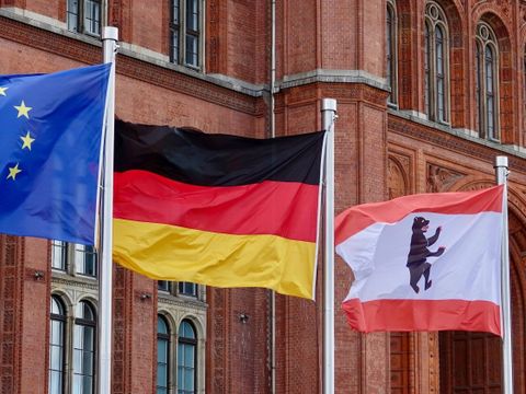 Drei wehende Flaggen vor dem Roten Rathaus, darunter die Europaflagge, die deutsche Flagge und die Berliner Landesflagge