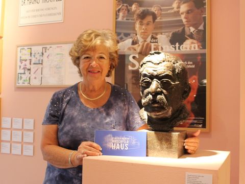 Gaby Cohen neben der Büste ihres Großonkels Magnus Hirschfeld im Schwulen Museum Berlin