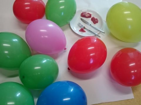 Rindfleischstücke auf einem Teller umgeben von 10 Luftballons