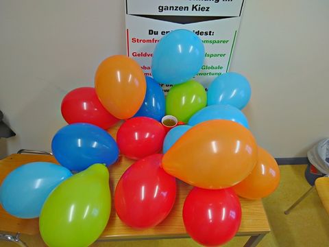 Eine Tasse Kaffee mit 16 bunten Luftballons