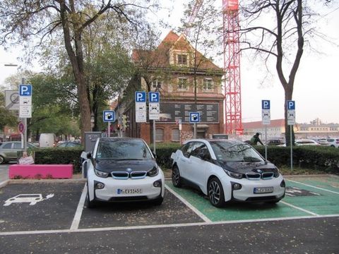 Mobilitätsstation am Münchner Zenettiplatz, mit zwei Carsharingfahrzeugen, umfangreichenn Hinweisschildern und Bodenmarkierungen