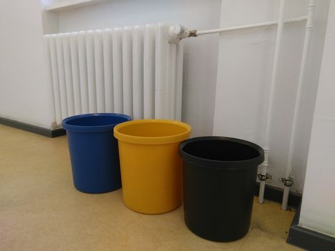 Leere Mülltonnen und Heizung unter einem Fenster