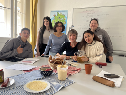 Das Team "Sprachunterricht in der Ulme 35" posiert beim gemeinsamen Frühstück. Auf dem Bild sind fünf Frauen und ein Mann.