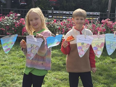 Mayra und Jakob haben gemeinsam mit ihren Klassenkamerad*innen Botschaften auf die selbstbemalten Papierpizzen geschrieben