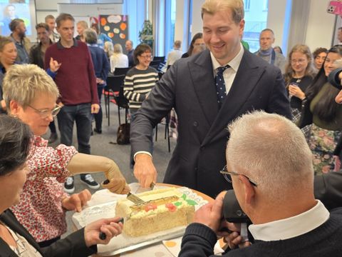 Gemeinsam schneiden die Gratulantinnen und Gratulanten die Jubiläumstorte an