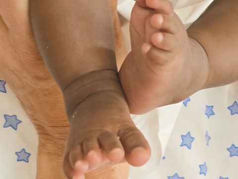 Beim Wickeln zeigt das Baby seine kleinen Füßchen