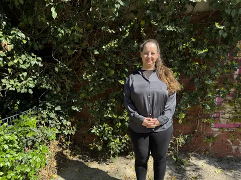 Anna Kuntze steht im Hof vor einer begrünten Mauer