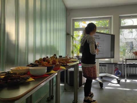 Auf den Tischen liegt das faire Frühstücksangebot mit Kaffee, Tee, Aufstrichen und Snacks sowie regionalen Ergänzungen bereit.