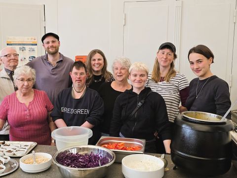 Gute Stimmung am Tresen: Das ehrenamtliche Team Herzraum Kreuzberg des Vereins bisous e.V. mit Clara Herrmann an der Essensausgabe