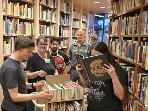 Gemeinsam bestückt das Team der Patientenbibliothek den kleinen Rollwagen mit den neuesten Schmökern für den Stationsbesuch