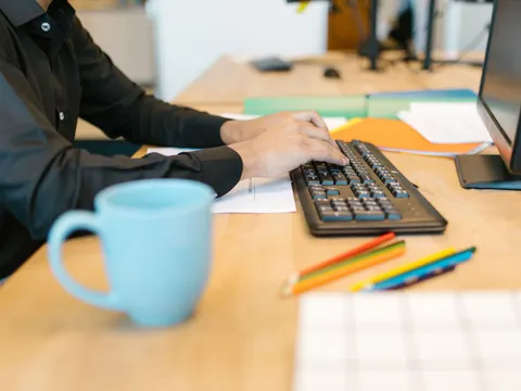Person arbeitet am Schreibtisch am Computer