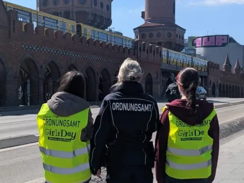 Die beiden Teilnehmerinnen des Girls'Day und eine Ordnungsamt-Mitarbeiterin posieren vor der Oberbaumbrücke.