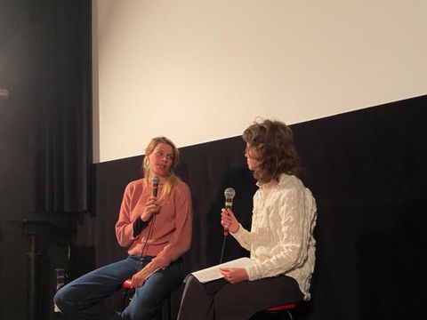 Zwie personen während einer Diskussionveranstaltung vor der weißen Leinwand in einem Kino