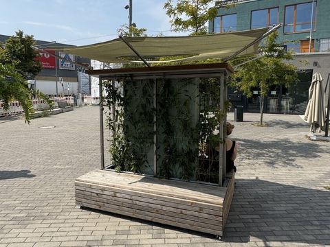 Zwei Sitzbänke mit einer begrünten Wand dazwischen und einem Sonnensegel darüber an der Yorckstraße