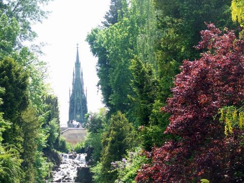 Das Foto zeigt einen Ausschnitt des Wasserfalls mit Blick auf das Schinkeldenkmal im Victoriapark in Kreuzberg.